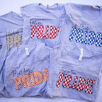 Five heather gray t-shirts with different collegiate-style 'Pride' graphics in red, white, blue, orange, and leopard print, arranged in a flat-lay collage.