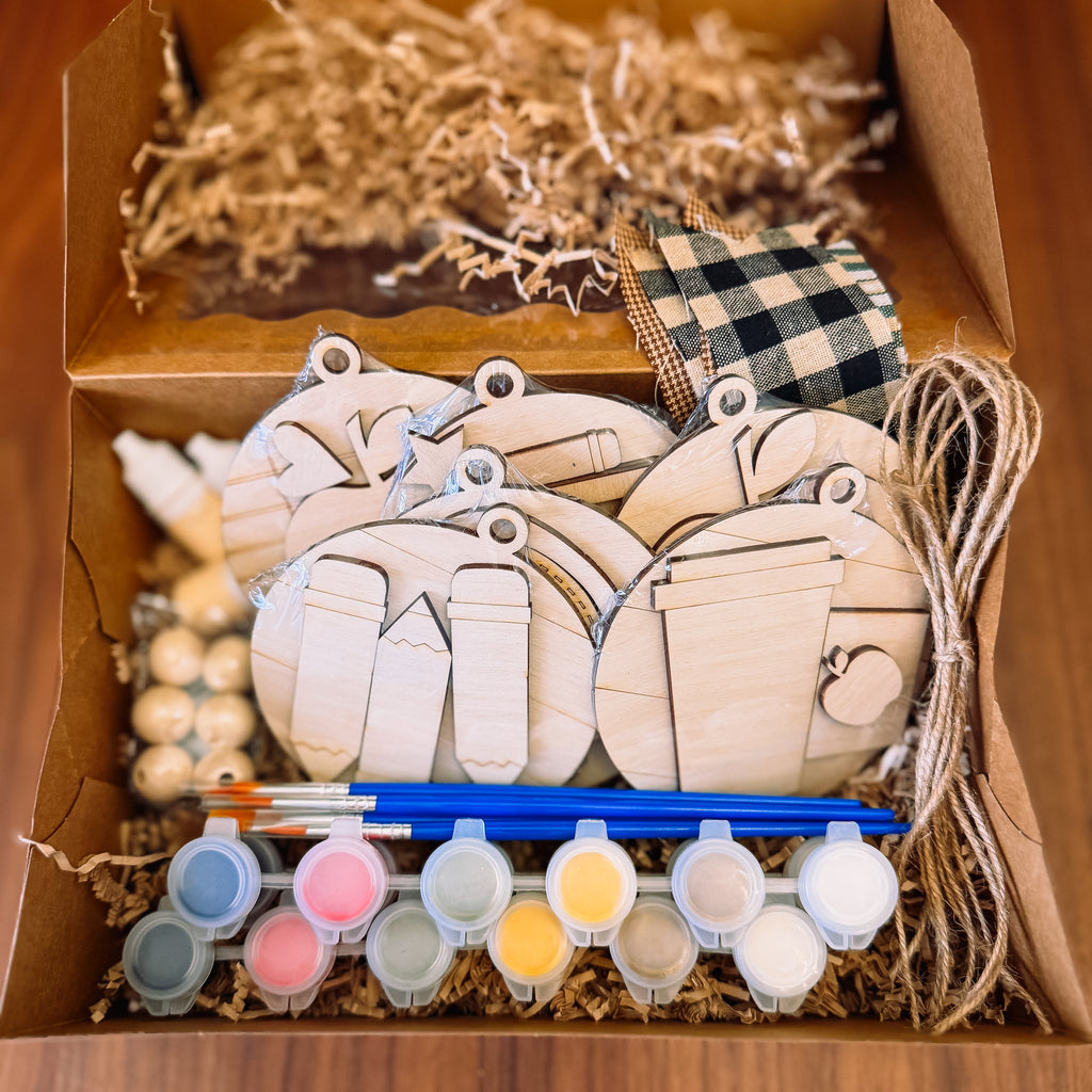 Wooden ornament gift set with paint and supplies.
