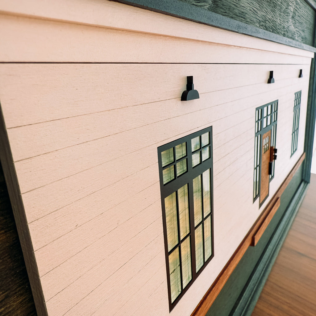 Close-up of a wooden cabin art with a window design on a wooden table.