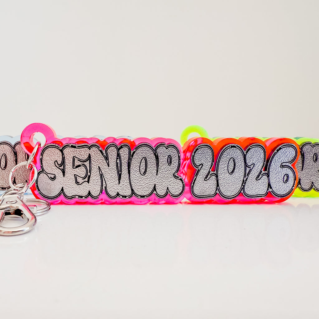 Colorful keychain with 'Senior 2026' text on a light gray background by October House Co. in Hartville, Ohio.