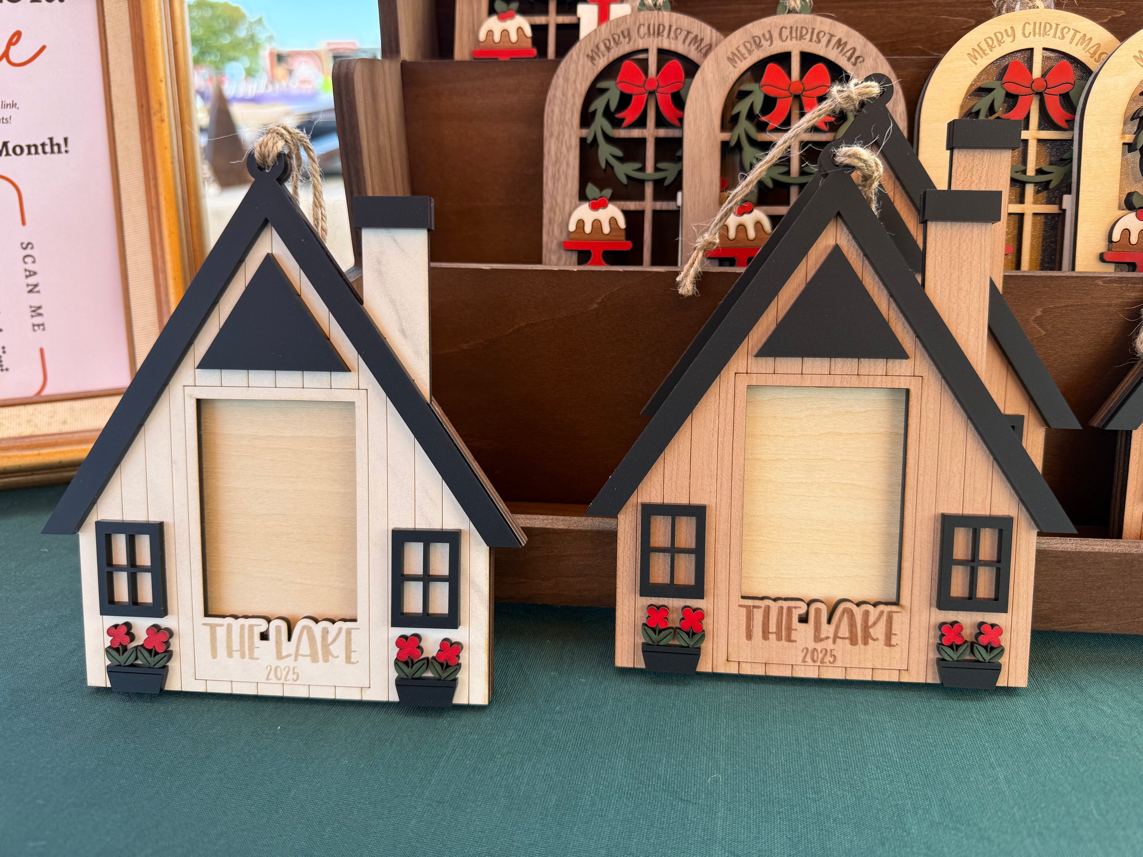 Wooden house-shaped ornaments with 'The Lake' 2025 Christmas Ornament by October House Co. in Hartville, Ohio.